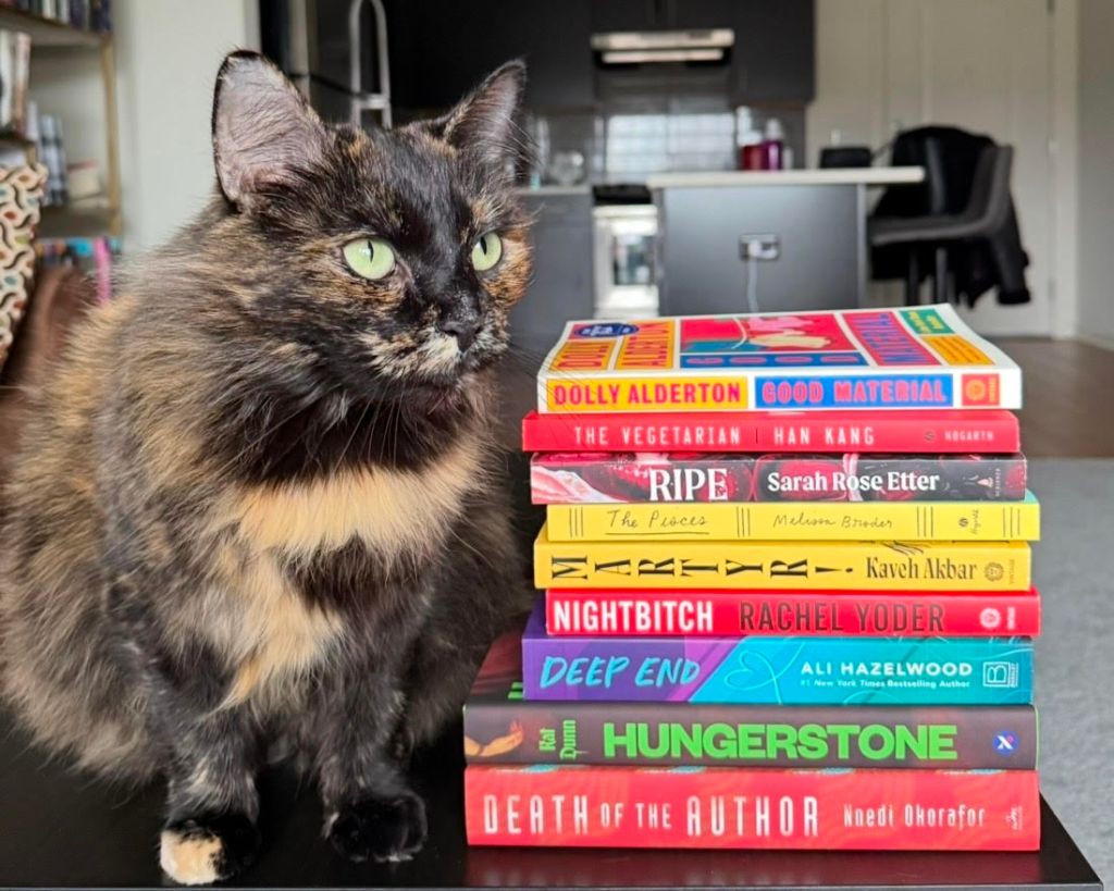 Chloe Ruffennach's cat, Karma, next to a stack of books.